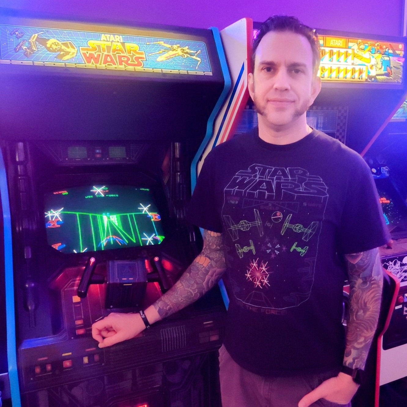 Jon Bunch standing next to an Atari Star Wars arcade cabinet